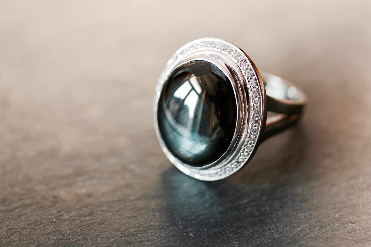 Bague "Grimsby". Or gris palladié, saphir noir étoilé 12 branches et diamants.