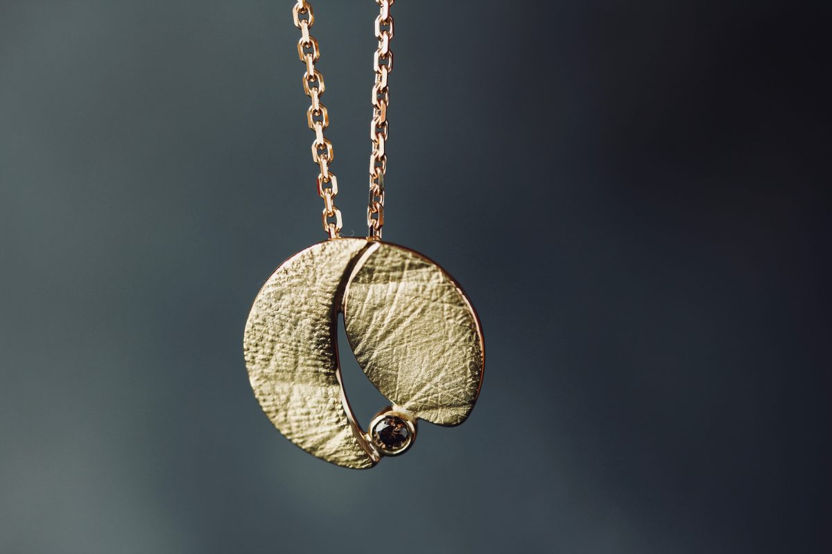 Médaille "Skin". Or jaune, empreinte des parents et diamant cognac.